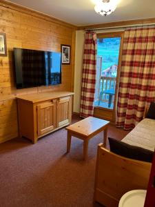a living room with a flat screen tv and a couch at Les alpages location appartement 108 in Lanslebourg-Mont-Cenis