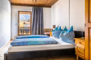 a bedroom with two beds with blue pillows and a window at Bauernhof Lehengut in Pfarrwerfen
