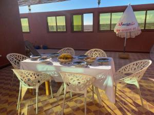 a white table with chairs and bowls of food on it at Birgits Bed & Bistro in Madkhal Meski