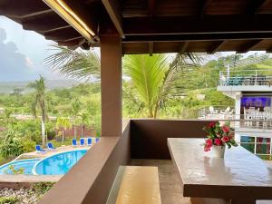 - une table avec un vase de fleurs à côté d'une piscine dans l'établissement Las Galeras Village Ecolodge, à Las Galeras