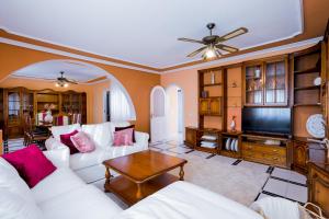 salon z białymi meblami i telewizorem z płaskim ekranem w obiekcie True Canarian 6 bedrooms villa with hot tub w mieście Callao Salvaje