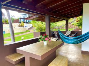 une terrasse avec un hamac, une table et des chaises dans l'établissement Las Galeras Village Ecolodge, à Las Galeras