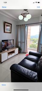 sala de estar con sofá y TV en Spacious 2-bedroom condo,Wifi,Netflix,Parking,Pool en Cagayán de Oro