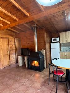 a living room with a fireplace in a log cabin at Cabañas Cortijo el Helao in Pozo Alcón