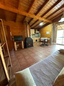 a living room with a fireplace and a table at Cabañas Cortijo el Helao in Pozo Alcón