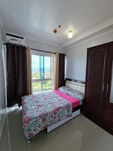 Habitación pequeña con cama y ventana en Spacious 2-bedroom condo,Wifi,Netflix,Parking,Pool en Cagayán de Oro
