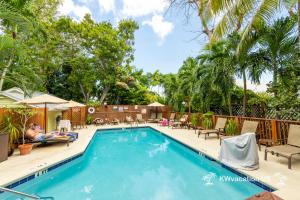 a man laying on a chair next to a swimming pool at The Island Suite at KW Vacation in Key West