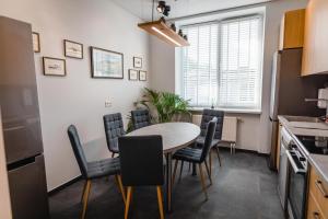a kitchen and dining room with a table and chairs at Birch Alley Self Check-In in Panevėžys