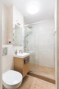uma casa de banho com um chuveiro, um WC e um lavatório. em Verdant Sadyba em Varsóvia