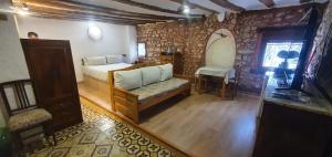 1 dormitorio con 1 cama y 1 silla en una habitación en El Bú, en Peralejos de las Truchas