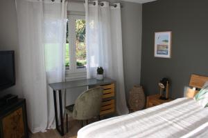um quarto com uma secretária, uma cama e uma janela em Le Mas de la Rocherie Chambre d'hôtes "Référence" em Pihen-lès-Guînes