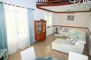 sala de estar con sofá blanco y sillas en Villa D ENNRY, en Pointe-Noire