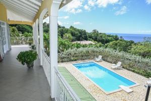 a house with a swimming pool on a balcony at Villa D ENNRY in Pointe-Noire