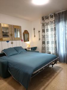 una camera con un grande letto e tende blu di L'oasis paisible a Castelnau-le-Lez
