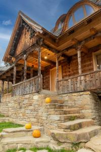 a wooden house with pumpkins on the steps at Poieni 39 in Poienile Izei