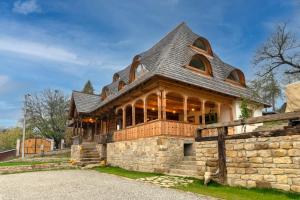 a stone house with a gambrel roof at Poieni 39 in Poienile Izei