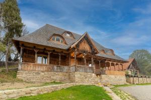 a large wooden house with a roof at Poieni 39 in Poienile Izei