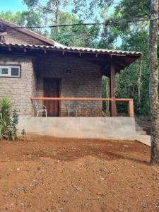 Casa pequeña de ladrillo con porche y patio en Bosque São Francisco, en Chapada dos Guimarães