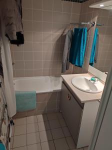 a bathroom with a sink and a tub and a toilet at T3 cosy au Jardin du Ramel in Luchon