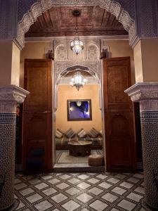 uma arcada num quarto com um sofá e uma mesa em Riad Layalina Fes 7 Chambres & 18 Personnes Piscine, Parking, Vue & Wifi au Pied Medina em Fez