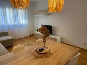 a dining room table with a vase on top of it at Apartamento con piscina Navarrete in Navarrete