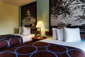 a hotel room with two beds and a picture of the capitol at Super 8 by Wyndham WestEnd Alexandria,VA Washington DC Area in Alexandria