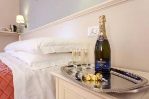 a bottle of wine on a tray next to a bed at Ottaviano Guest House in Rome