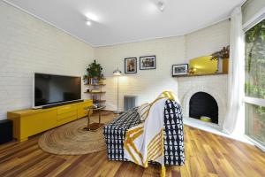 sala de estar con TV y chimenea en Carlton Dream: Leafy 2bed 2bath Lygon Str Townhouse, en Melbourne