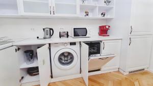 - une buanderie blanche avec lave-linge et sèche-linge dans l'établissement Spacious 5* luxury in historic center free parking, à Cluj-Napoca