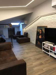 een woonkamer met een bank en een flatscreen-tv bij Gioconda’s Apartment in Rome