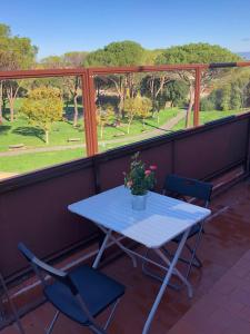 a table and chairs on a balcony with a view of a park at Gioconda’s Apartment in Rome