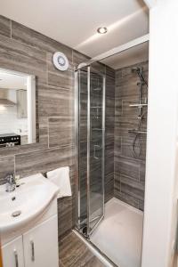 a bathroom with a shower and a sink at Patio lodge with forest access close to beaches in South Wootton