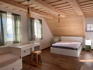 a bedroom with a bed and a bench and windows at Roubenka ARCHA in Dolní Morava