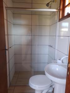 a bathroom with a toilet and a sink at Pousada Taiani in Itaara