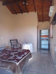 a bedroom with a bed and a table in a room at Pousada Taiani in Itaara