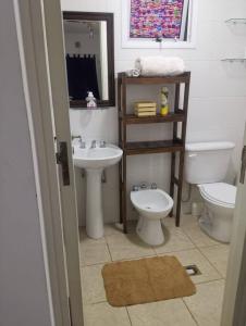 een badkamer met een wastafel, een toilet en een spiegel bij Hermoso y cómodo apartamento.- in Mendoza