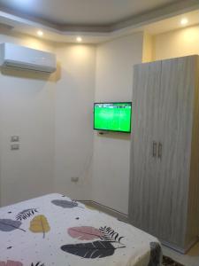 um quarto com uma cama e uma televisão de ecrã plano em كذا بلانكا بيتش 220 em Hurghada