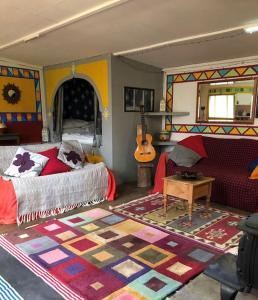 Un dormitorio con una cama y una guitarra. en Secret Woodland Hideaway for two en Ilfracombe