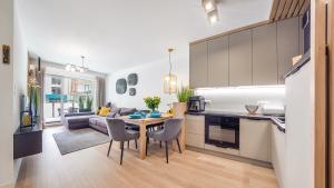 a kitchen and living room with a table and a couch at Rybacka Kołobrzeg in Kołobrzeg +12 photos