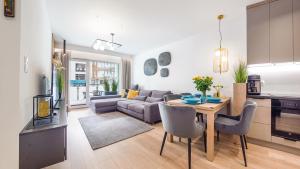 a kitchen and living room with a table and a couch at Rybacka Kołobrzeg in Kołobrzeg