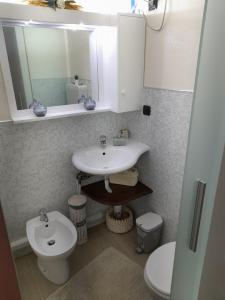 a bathroom with a sink and a toilet and a mirror at Condominio - Guglielmo Tell in Sestriere
