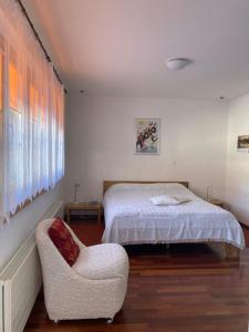 um quarto com uma cama e uma cadeira em Guardaval em Arosa