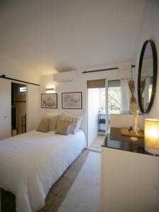 a white bedroom with a large bed and a mirror at Sublime Villa Piscine Jacuzzi Côte d'Azur in Mouans-Sartoux