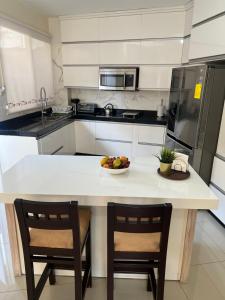 una cocina con mesa con 2 sillas y un bol de fruta en Garzota Suites Airport Bajos, en Guayaquil 17 fotos más