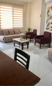 瓜亞基爾的住宿－Garzota Suites Airport Bajos，客厅配有沙发和桌子