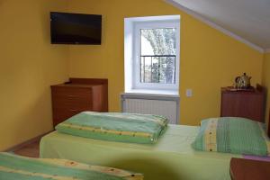 a bedroom with a bed with a television on the wall at Ośrodek Wypoczynkowy Pod Skałką in Szczytna