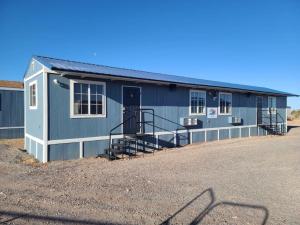 a small blue building with stairs in a parking lot at 069B Cozy Suite Kitchen & King Bed near South Rim in Valle