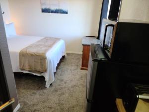 a hotel room with a bed and a flat screen tv at 069B Cozy Suite Kitchen & King Bed near South Rim in Valle