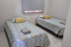 duas camas sentadas uma ao lado da outra num quarto em Impecable y nuevo, zona aeropuerto! em Assunção