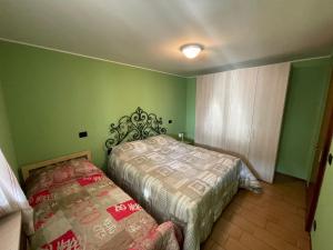 um quarto com 2 camas e paredes verdes em Rosa Mountain Lake Iseo Hospitality em Bossico